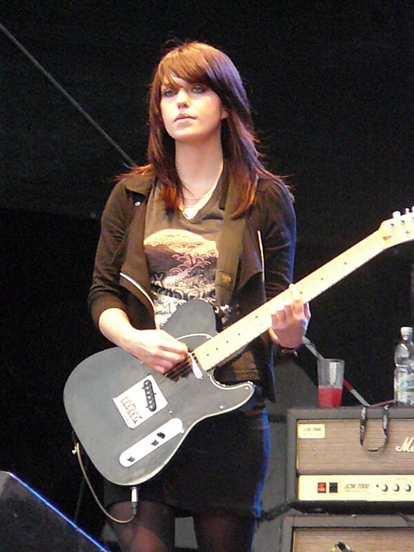 woman playing electric guitar