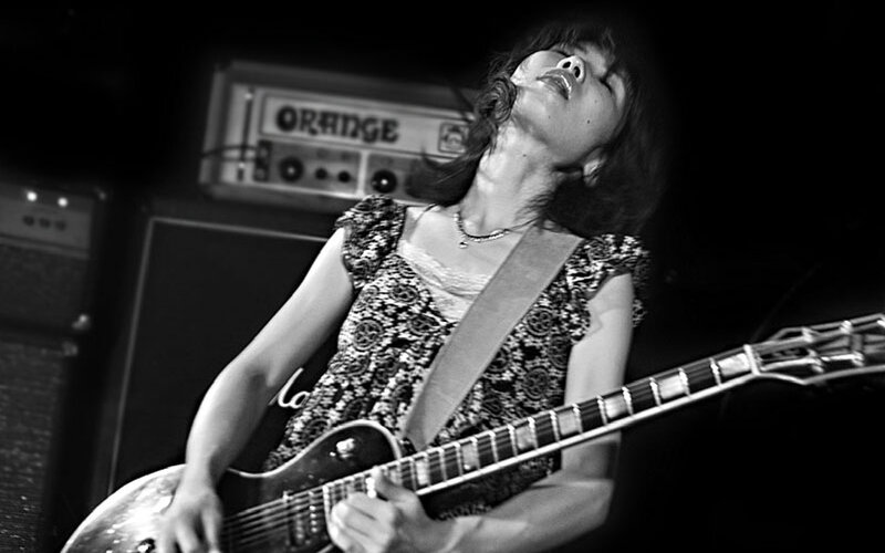 Woman Playing Electric Guitar — Black, Intense