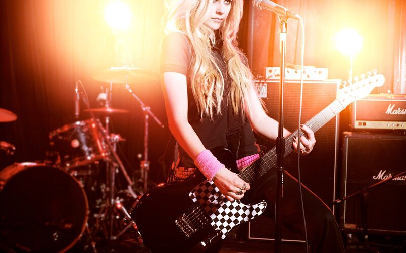 woman playing electric guitar on stage