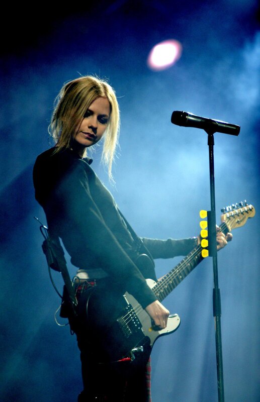 woman playing electric guitar on stage