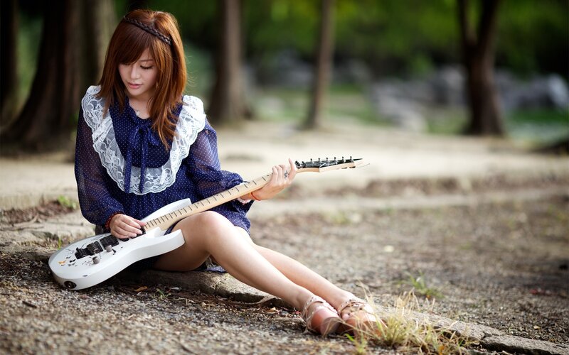 Woman playing electric guitar outdoors