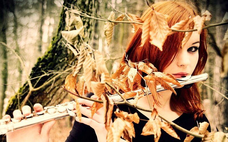 woman playing flute in forest