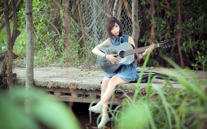 Woman playing guitar in nature