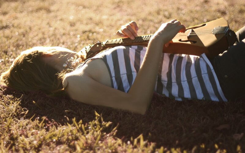 Woman playing guitar on grass