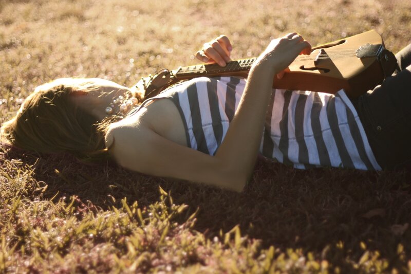 Woman playing guitar on grass