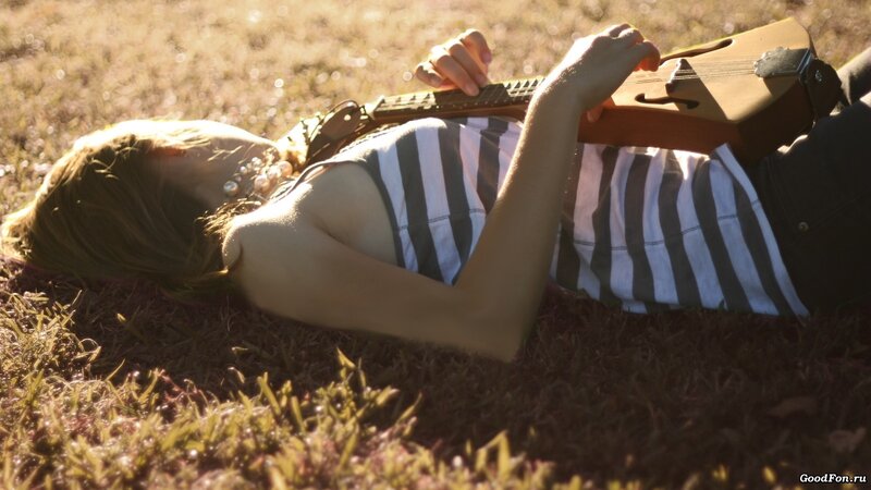 Woman playing guitar on grass