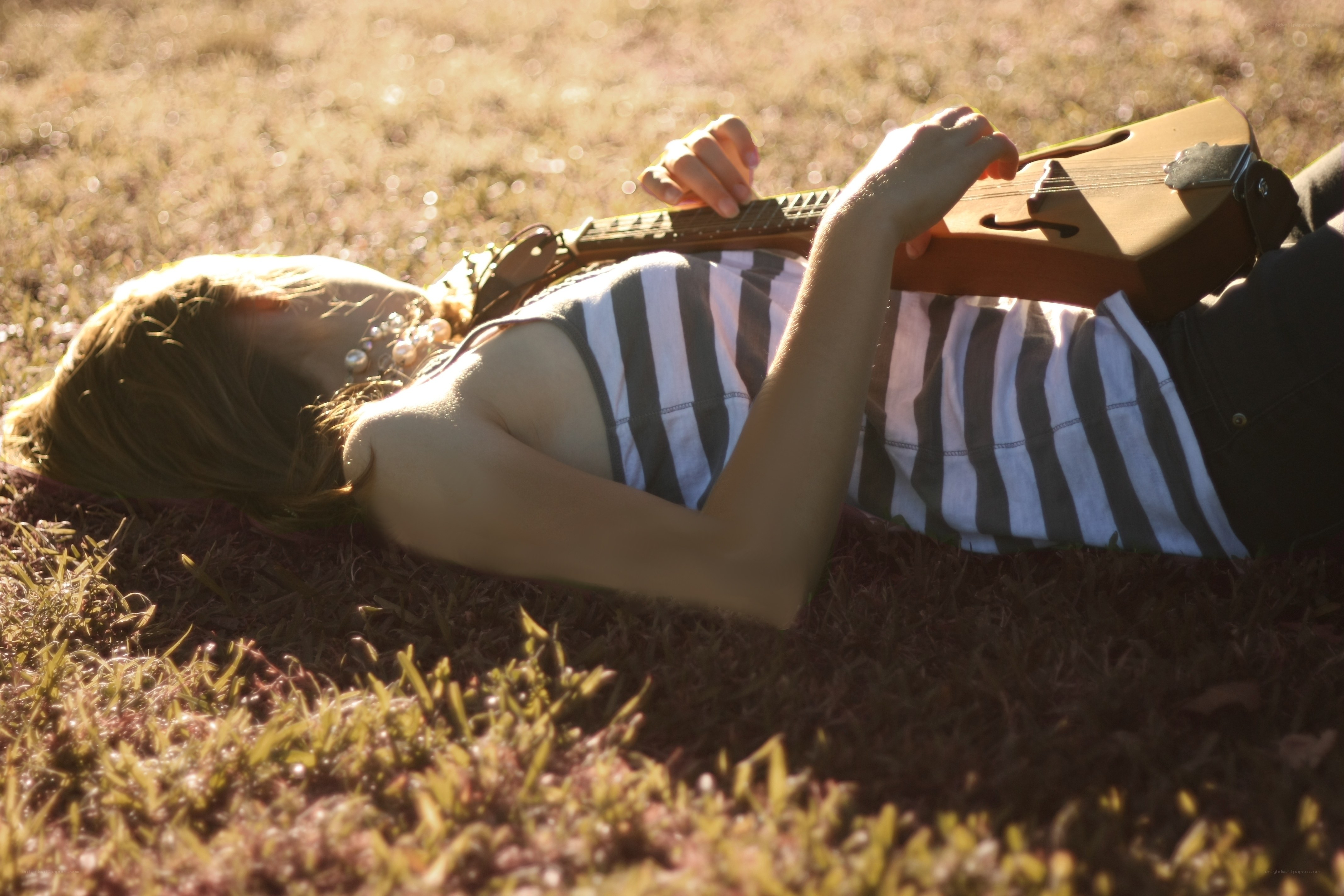 Woman playing guitar on grass