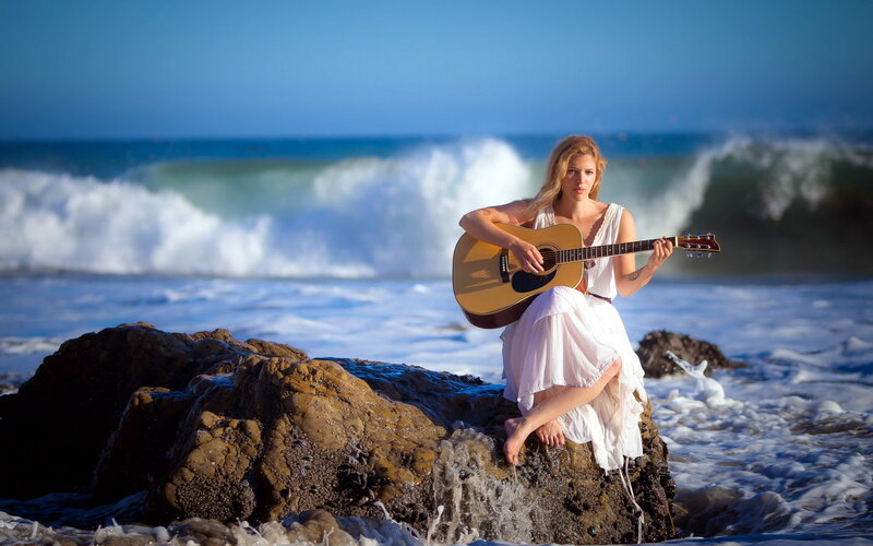 Woman Playing Guitar on Rock