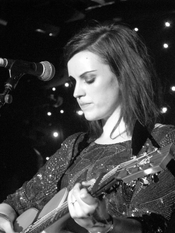woman playing guitar on stage