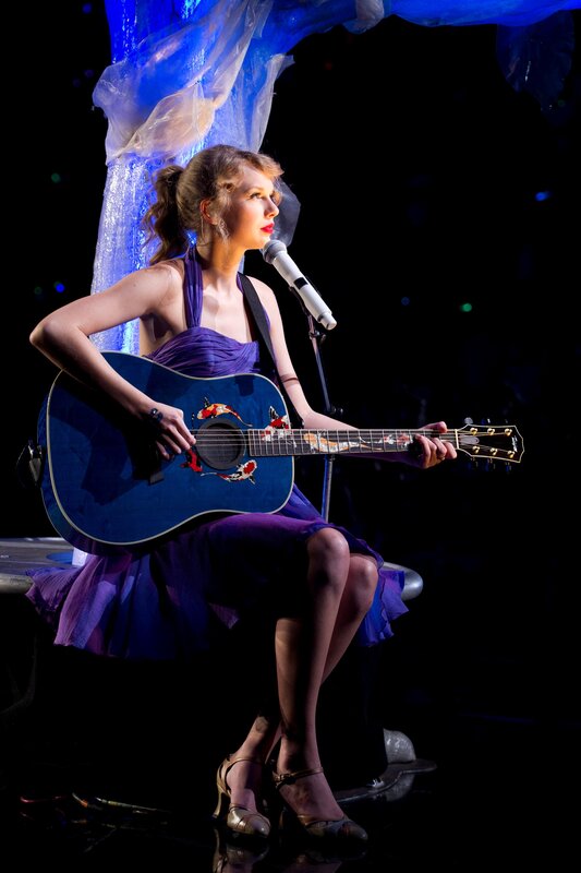 woman playing guitar on stage