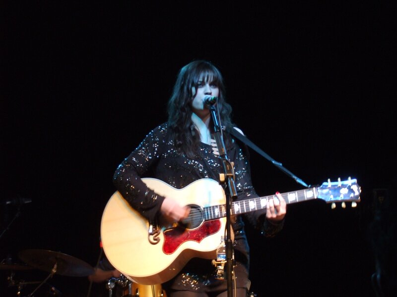 Woman playing guitar on stage