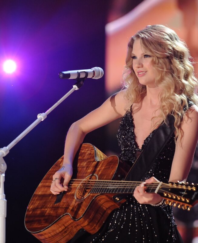 woman playing guitar on stage