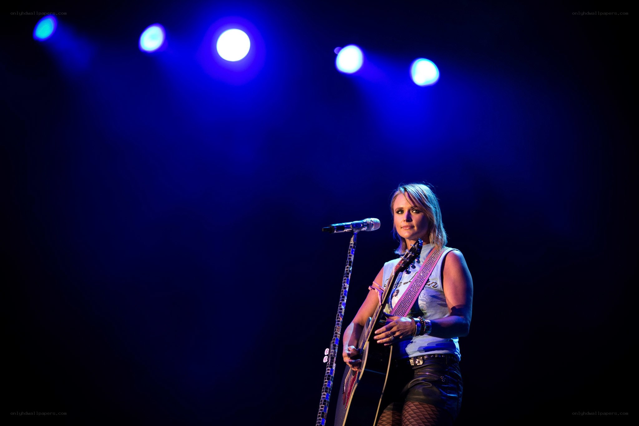 Woman playing guitar on stage