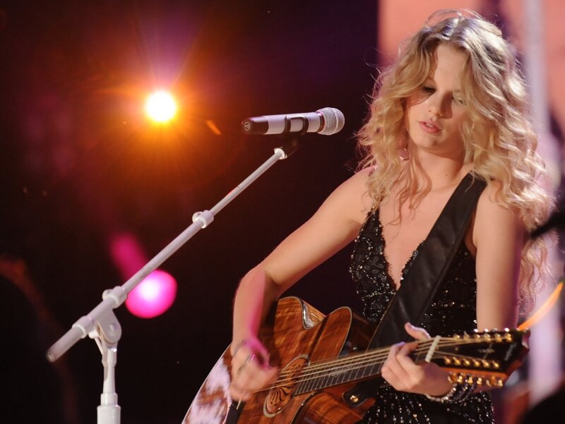 woman playing guitar on stage