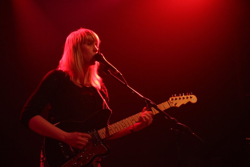 woman playing guitar on stage