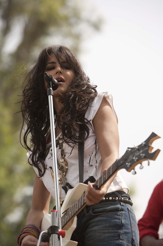 woman playing guitar on stage