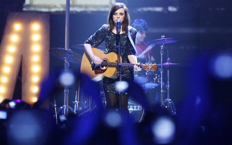 woman playing guitar on stage