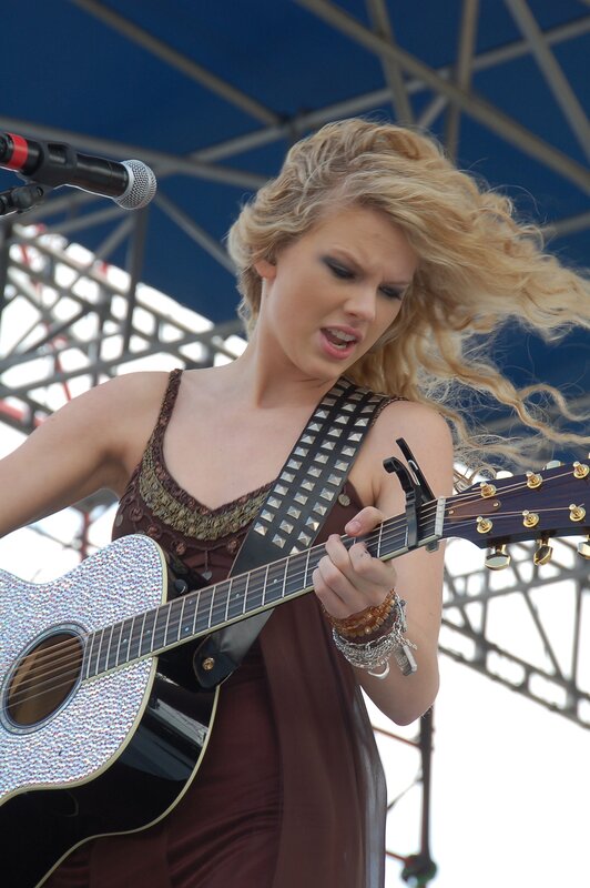 woman playing guitar on stage