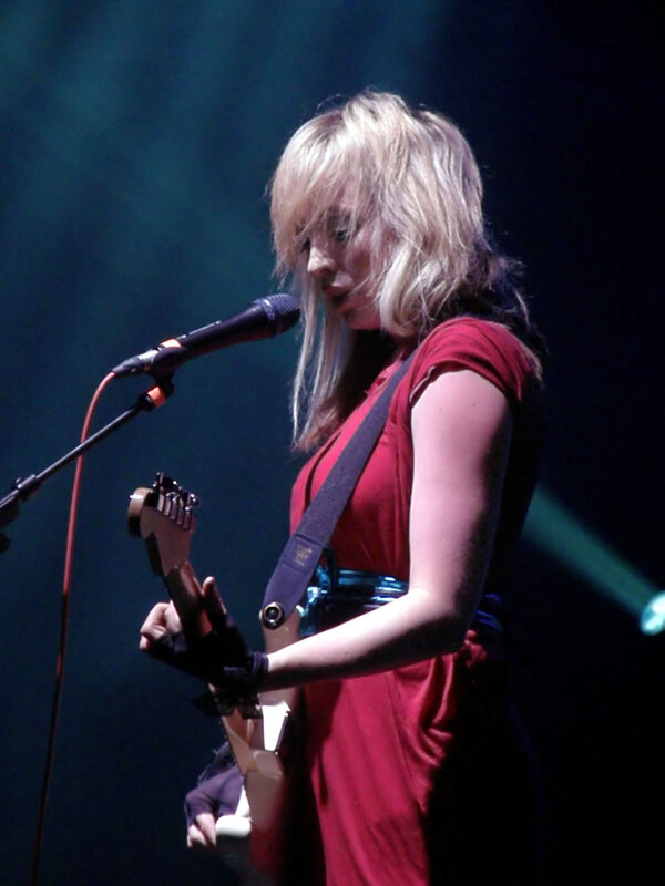 Woman playing guitar on stage