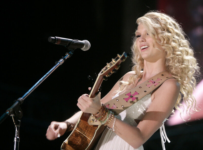 woman playing guitar on stage