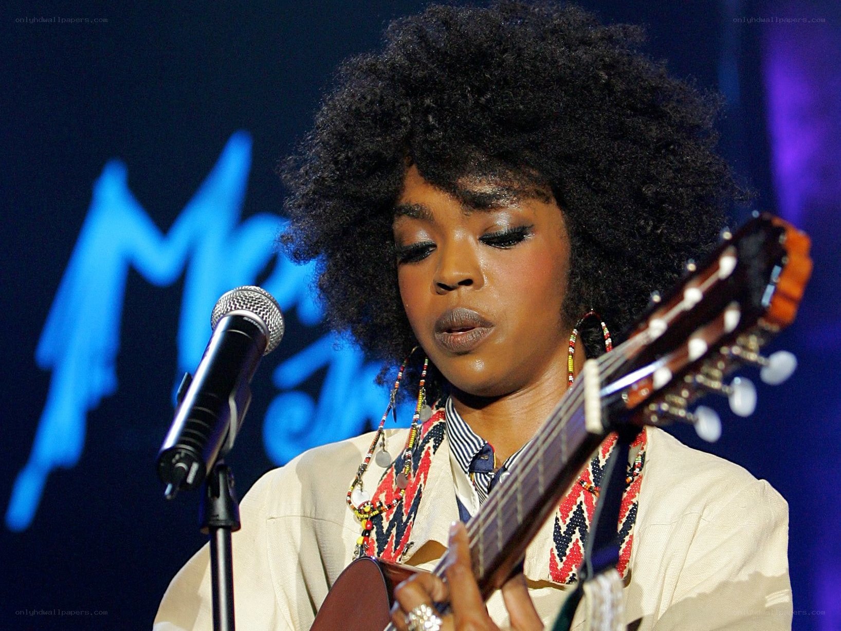 woman playing guitar on stage