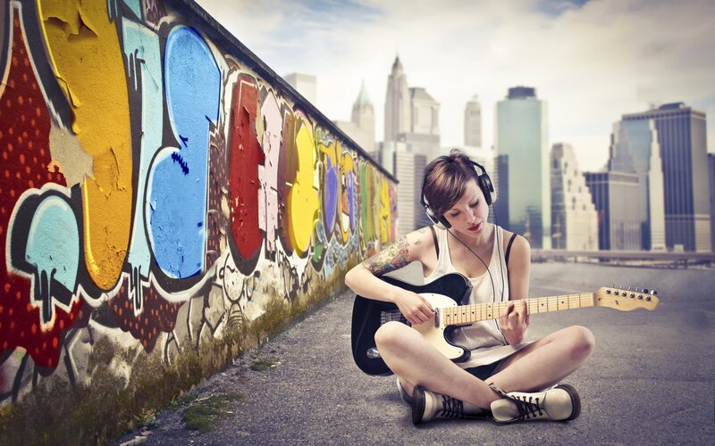 Woman playing guitar on street