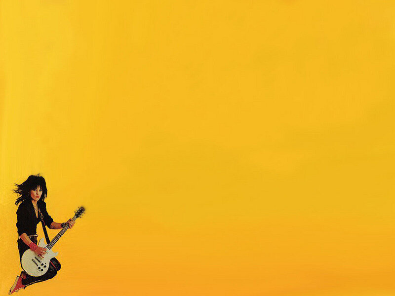 woman playing guitar on yellow