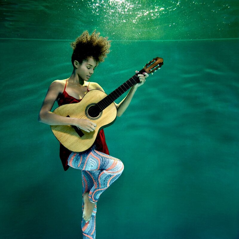 Woman playing guitar underwater