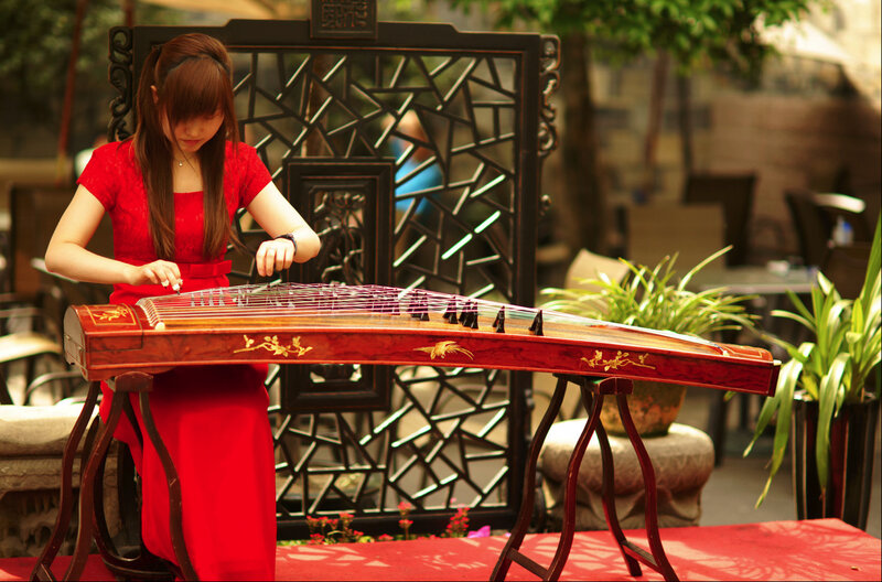 Woman playing guzheng outdoors