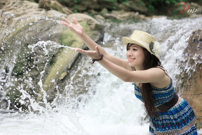 Woman playing in waterfall