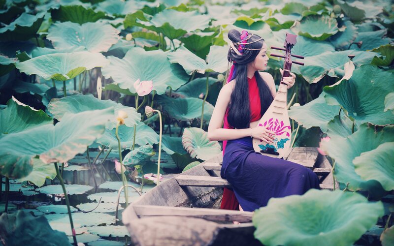 Woman playing lute in lotus pond