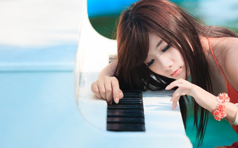 woman playing piano by water