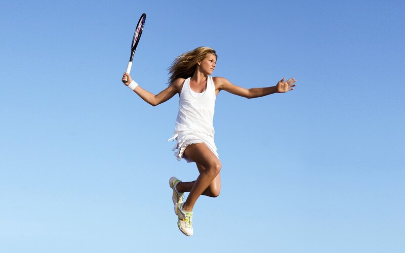 woman playing tennis in mid-air