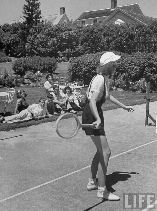Woman playing tennis with spectators