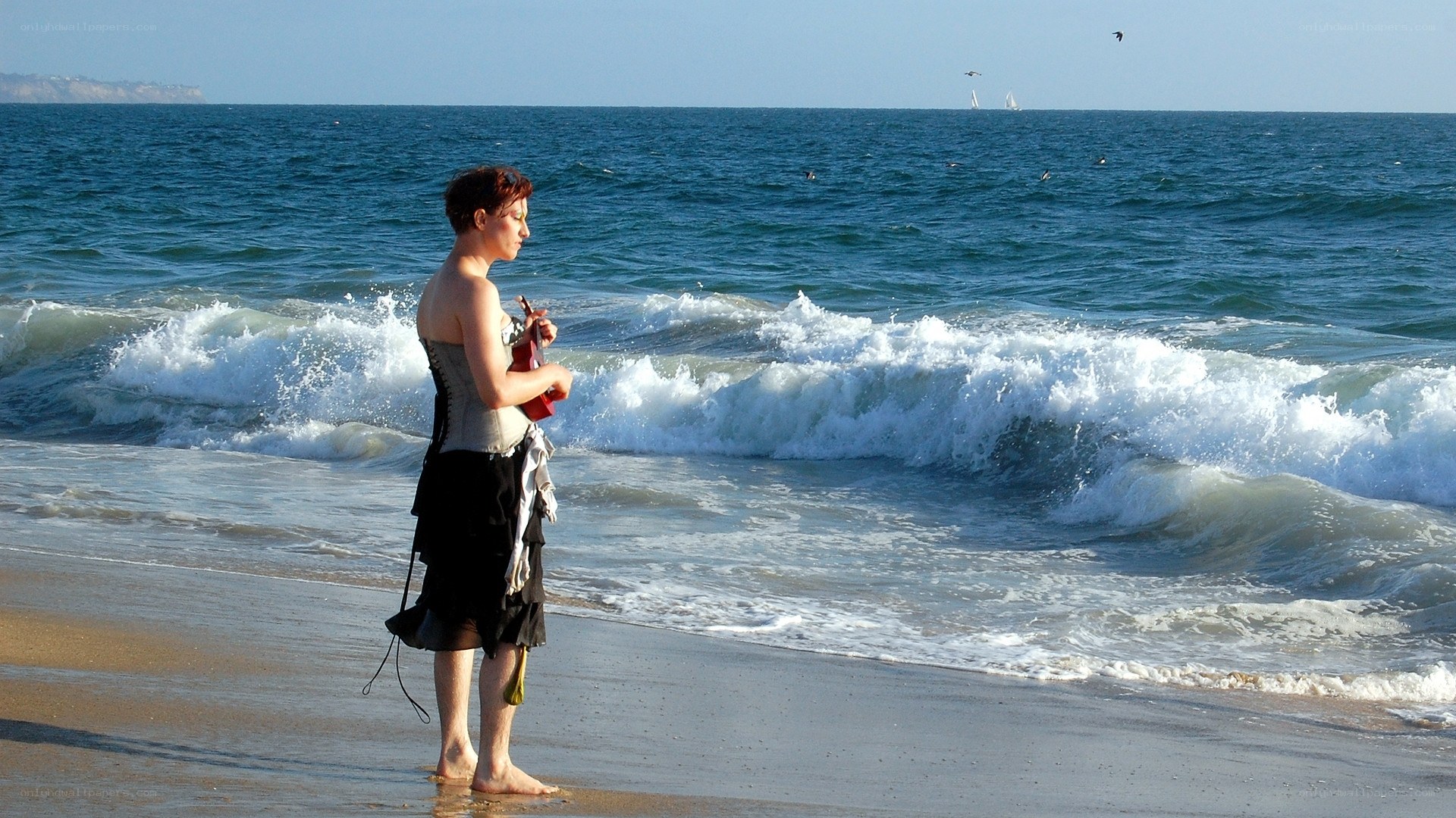 Woman playing ukulele on beach