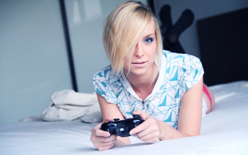 woman playing video game on bed