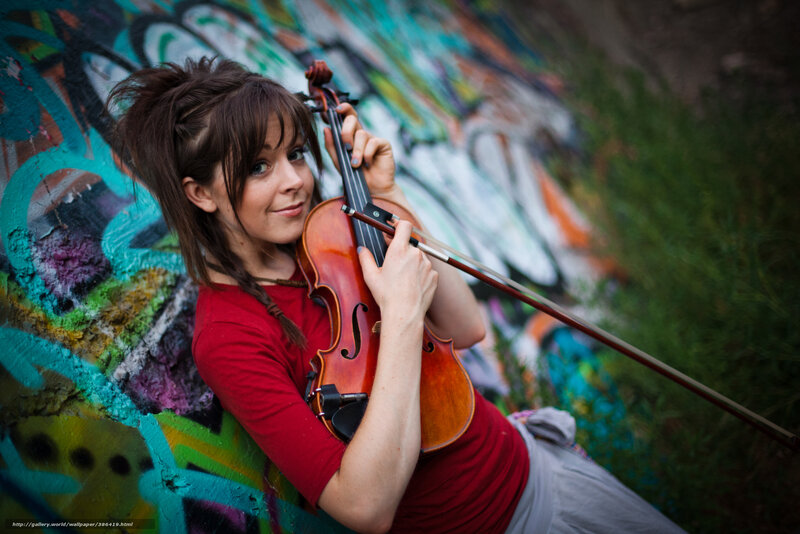 woman playing violin against graffiti