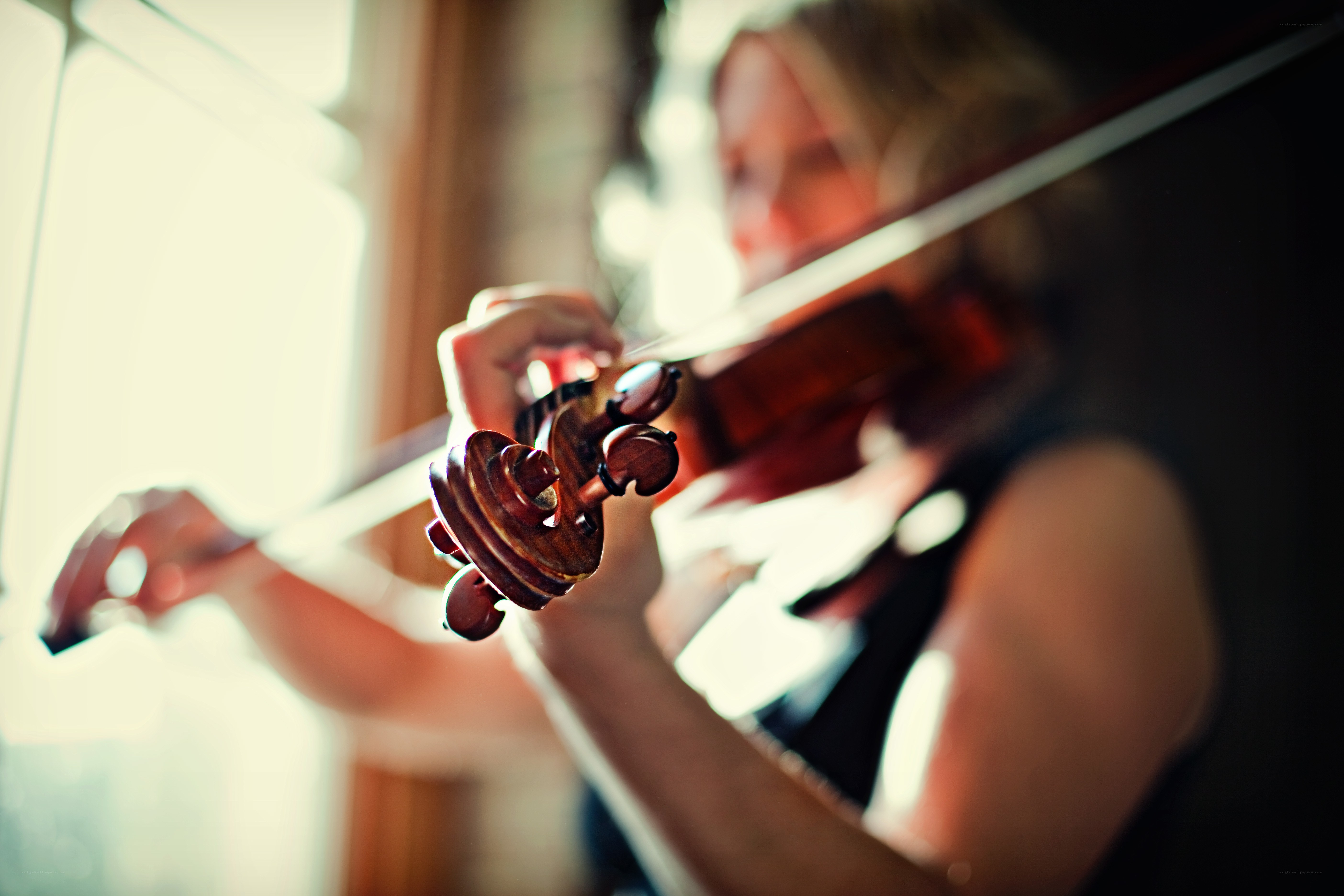 woman playing violin by window