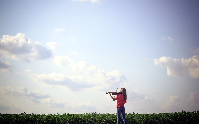 Woman playing violin in a field