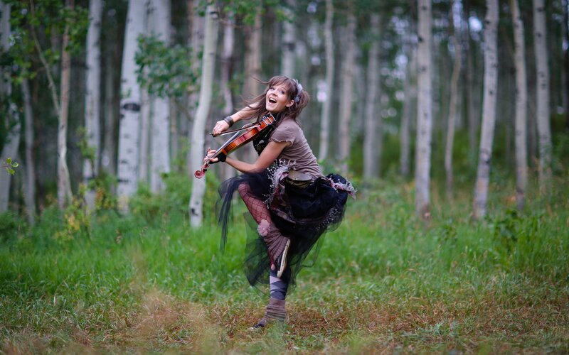 Woman playing violin in forest