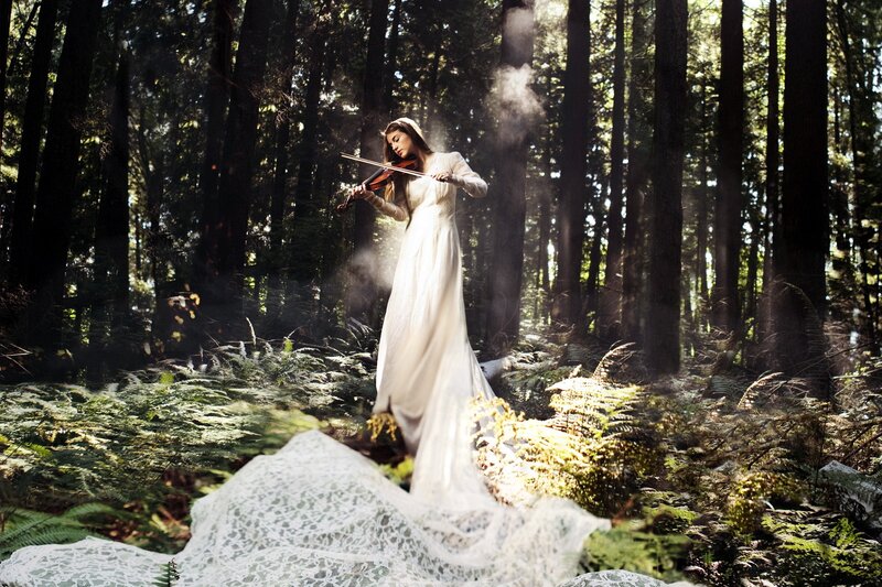 Woman playing violin in forest
