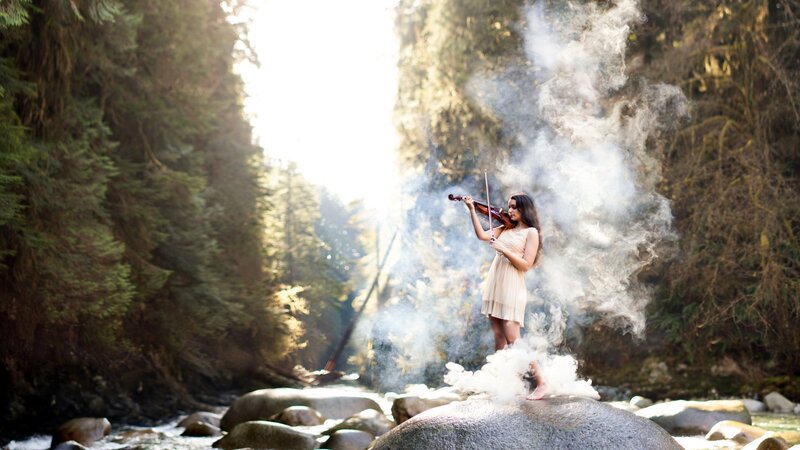 Woman playing violin in forest