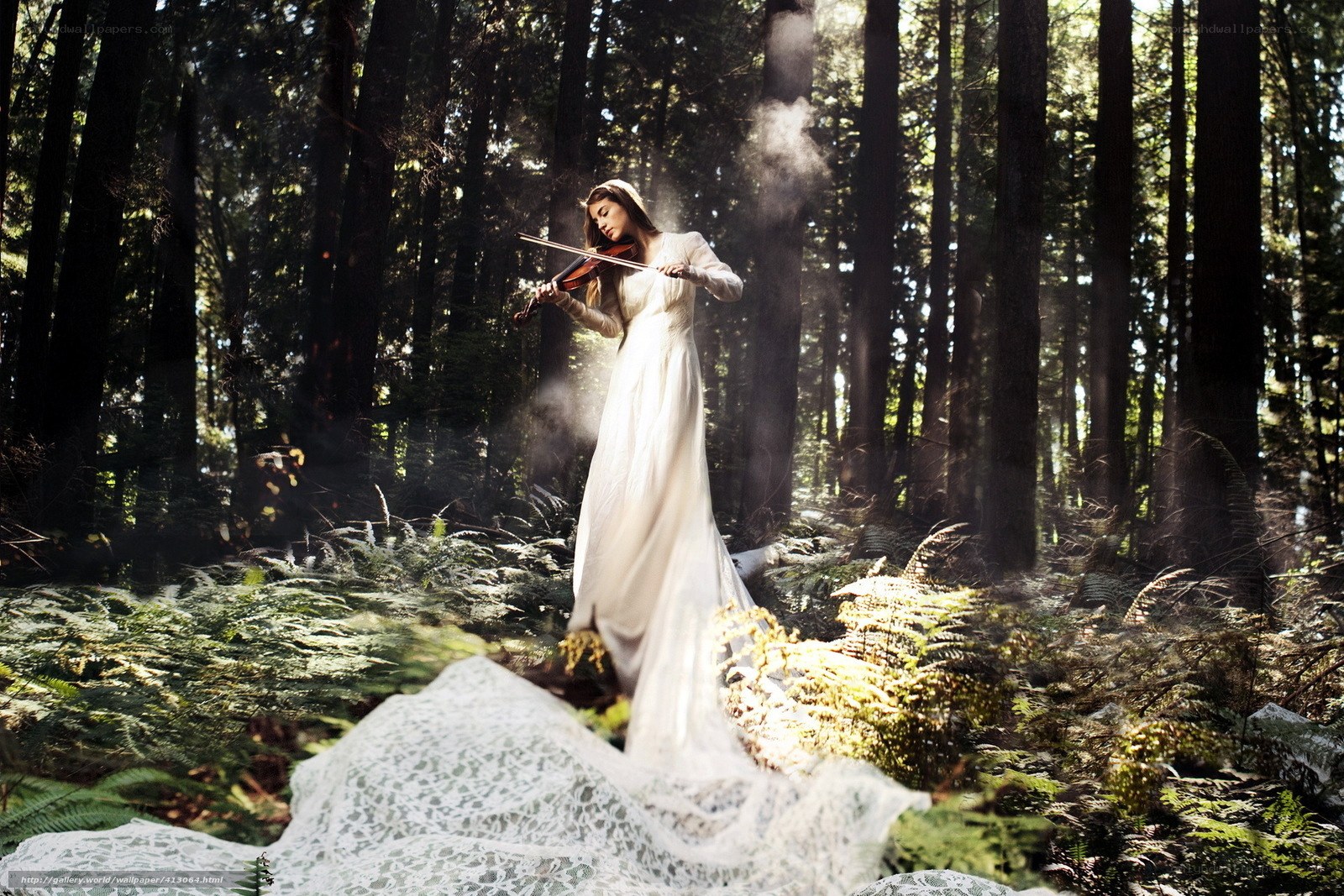 Woman playing violin in forest