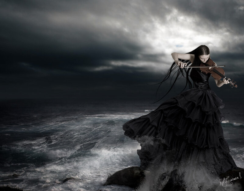 Woman playing violin on cliff