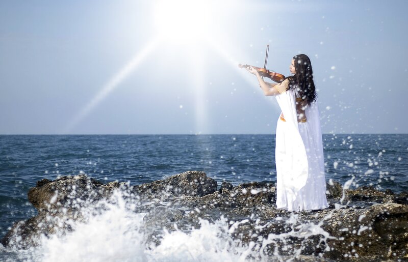 Woman Playing Violin — White, Serene, Afternoon, Photograph, Ocean, Rocks