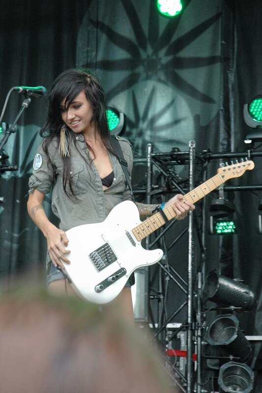 Woman playing white electric guitar