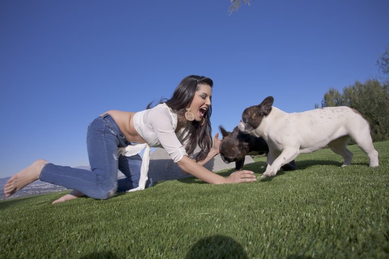 Woman playing with dogs on grass
