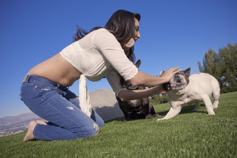 Woman playing with dogs outdoors