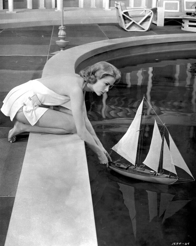 woman playing with model sailboat