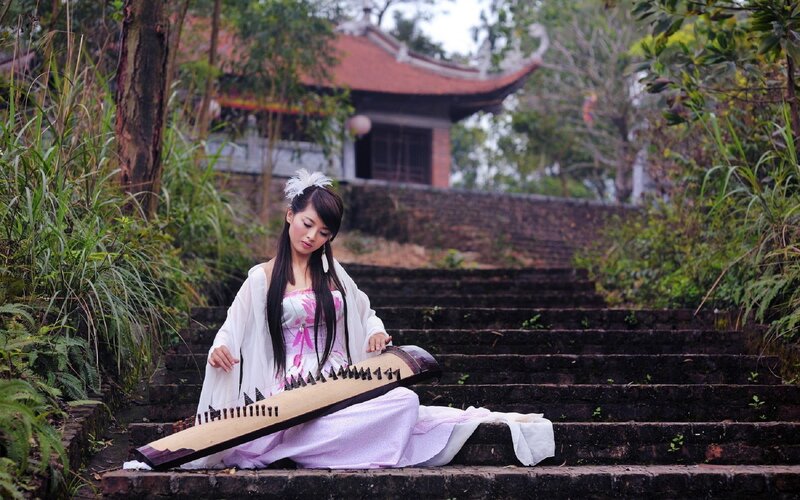 Woman playing zither on steps